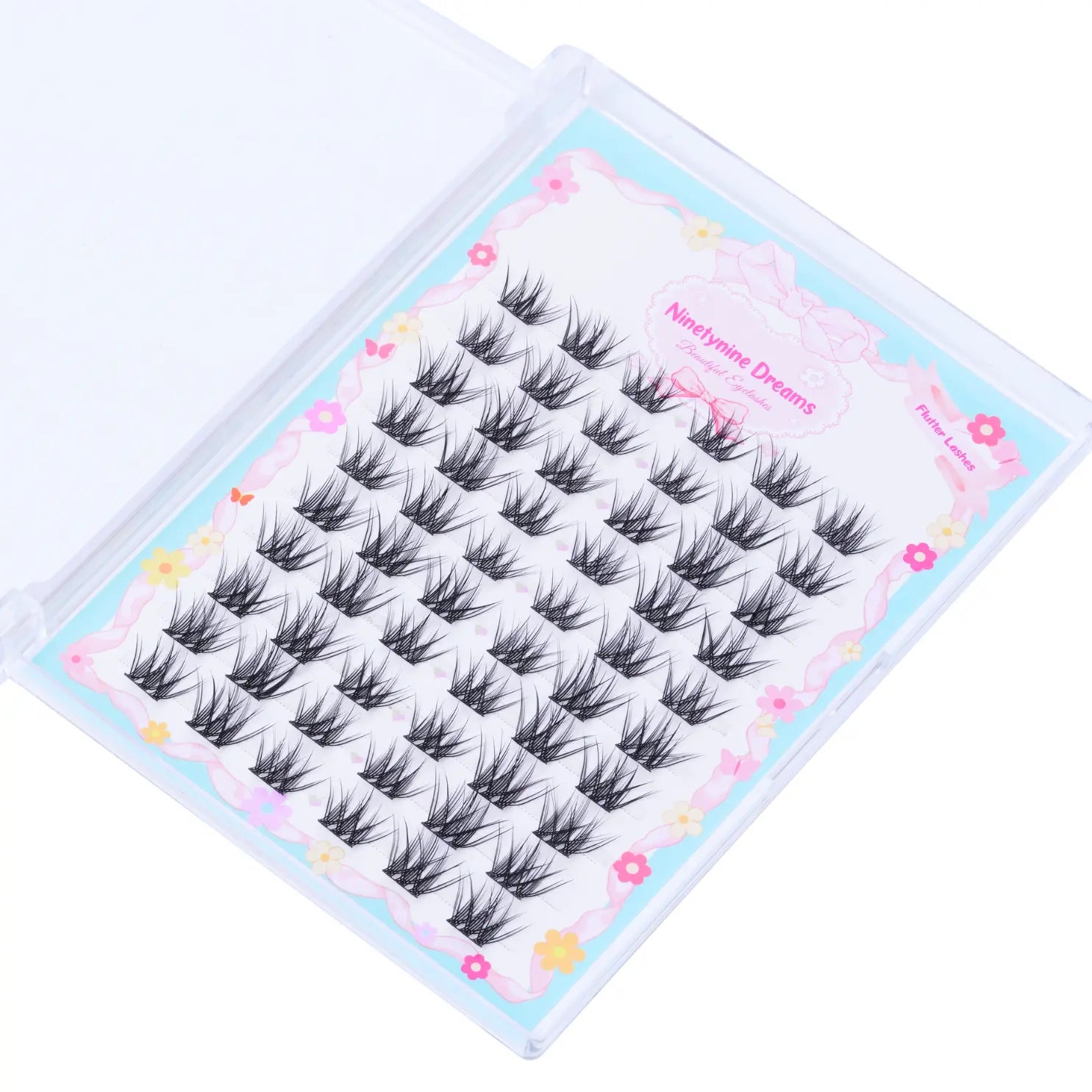 A top-down view of the 60PCs Flutter Lashes from Ninetynine Dreams, showcasing their delicate, wispy design. The lashes are neatly arranged, highlighting their soft volume, natural curl, and lightweight feel. This angle provides a clear look at the lash clusters and fine synthetic fibers, perfect for achieving a fluttery, effortless eye look.