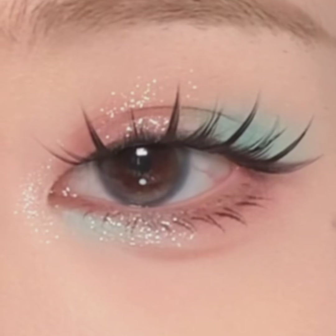 Close-up video of eye wearing Ninetynine Dreams Cloud Nine lashes with pastel eyeshadow and glitter, showcasing wispy lash look
